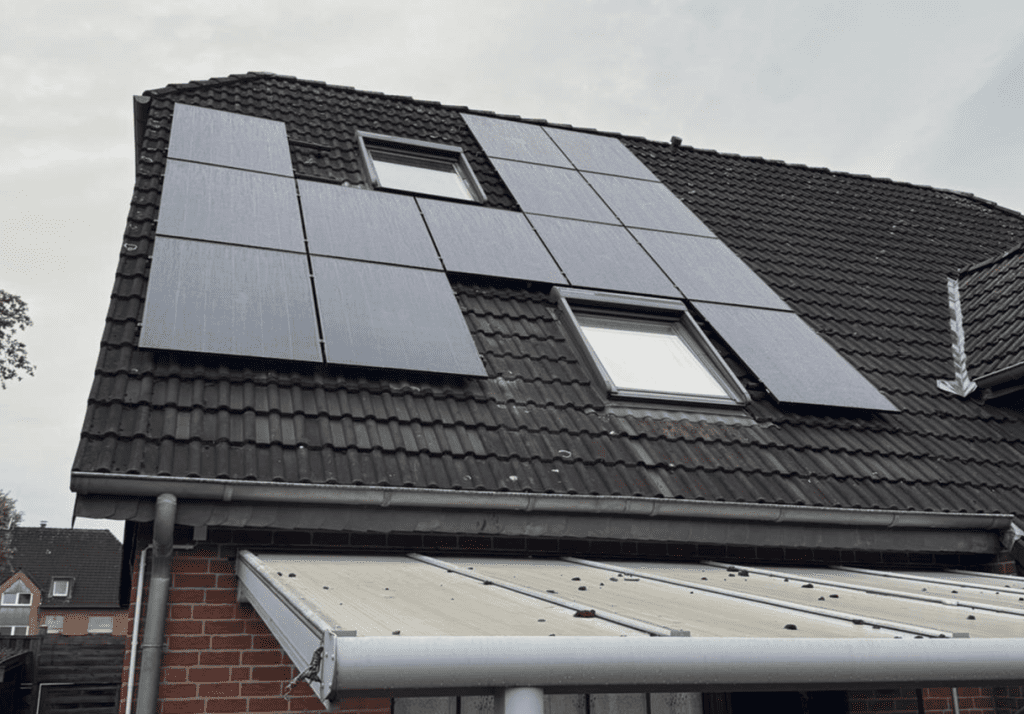 Neuinstallierte Photovoltaikanlage auf dem Dach eines älteren Hauses.