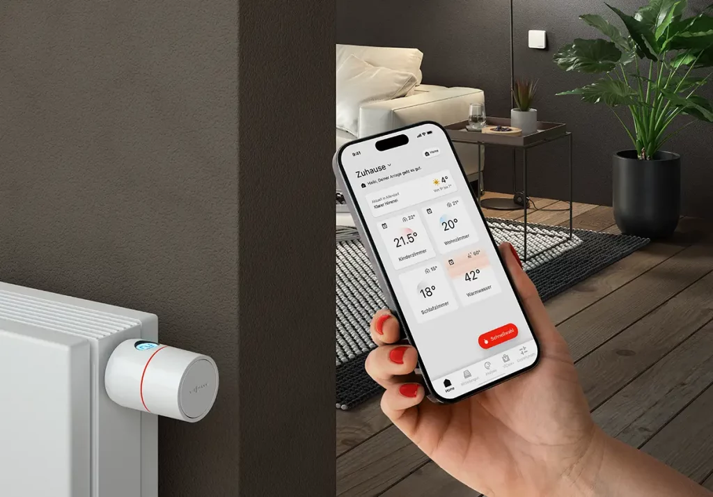 Handy mit geöffneter VIESSMANN ViCare-App in einem Wohnzimmer.