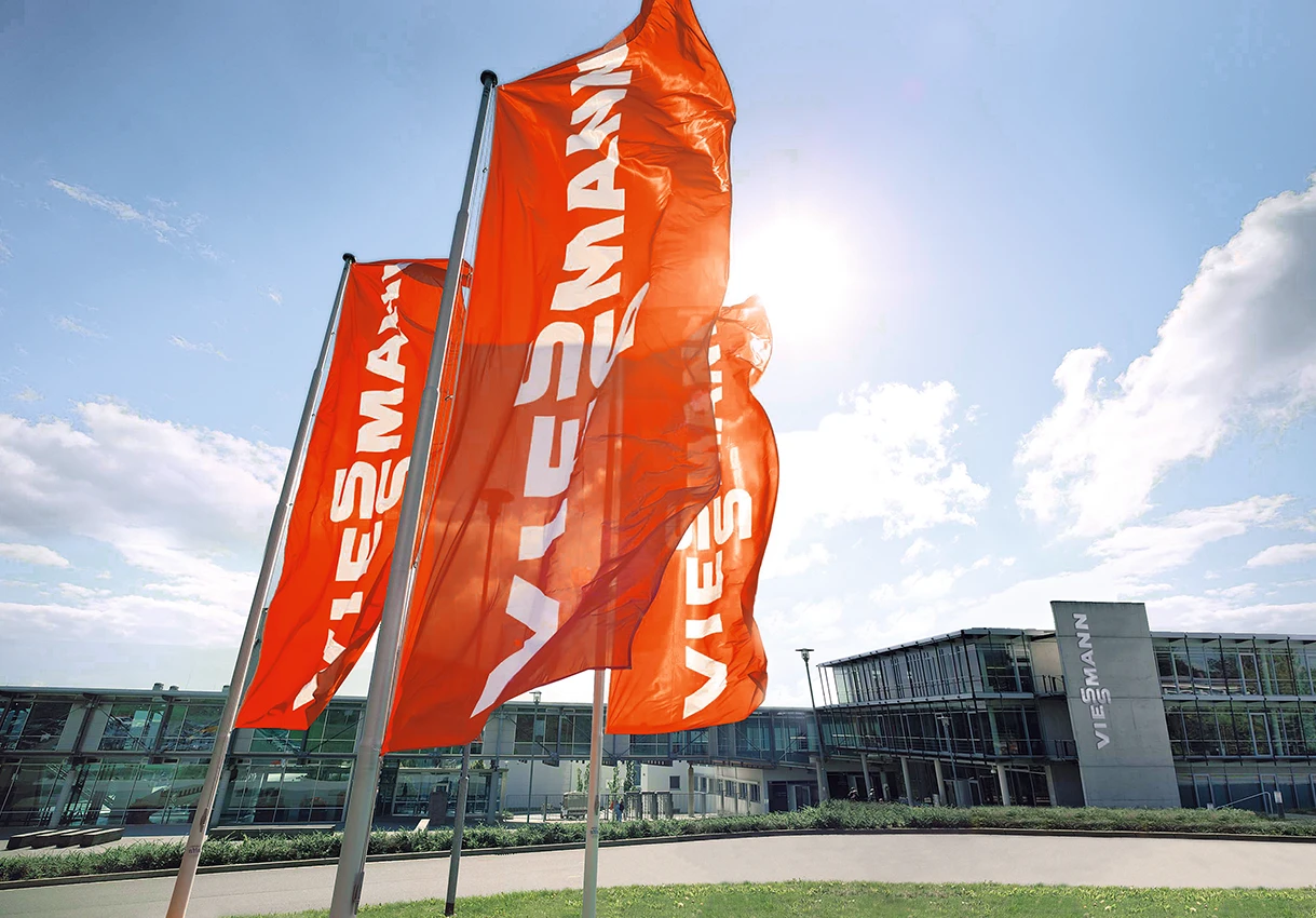 Rote Viessmann Flaggen bei gutem Wetter vor der modernen Viessmann Firmenzentrale.